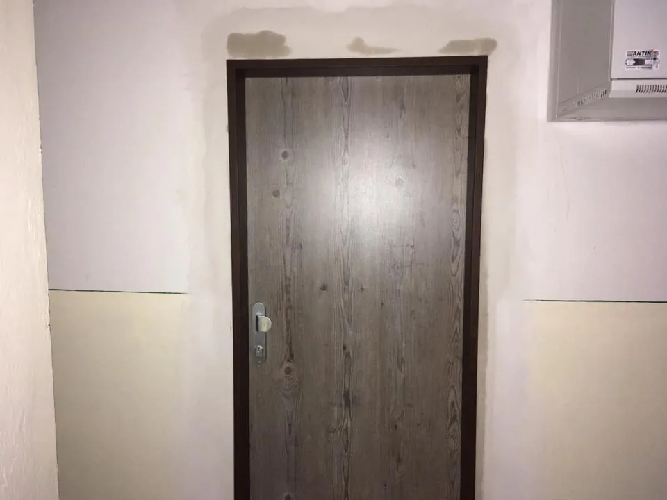 Osadené tmavé bezpečnostné dvere v chodbe bytového domu