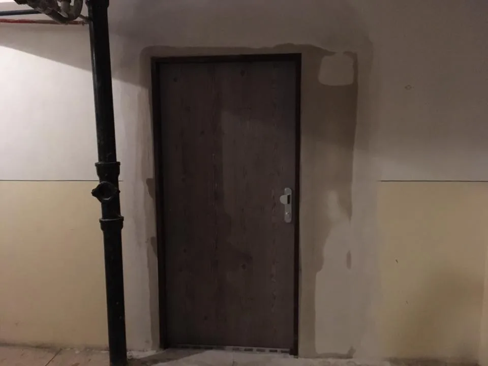 Tmavé bezpečnostné dvere v chodbe bytového domu