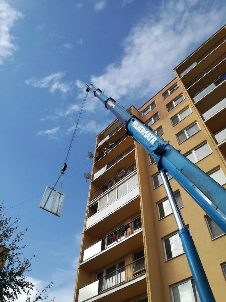 Zavesená presklená výplň stúpa pozdĺž balkónov bytového domu