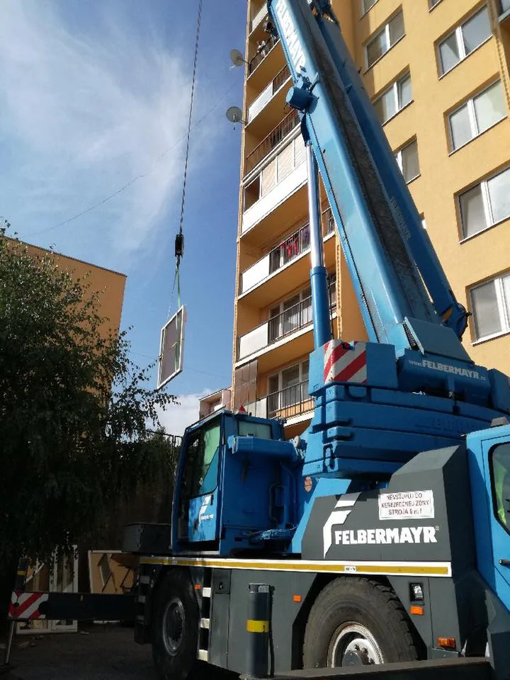 Mobilný žeriav postavený pri bytovom dome